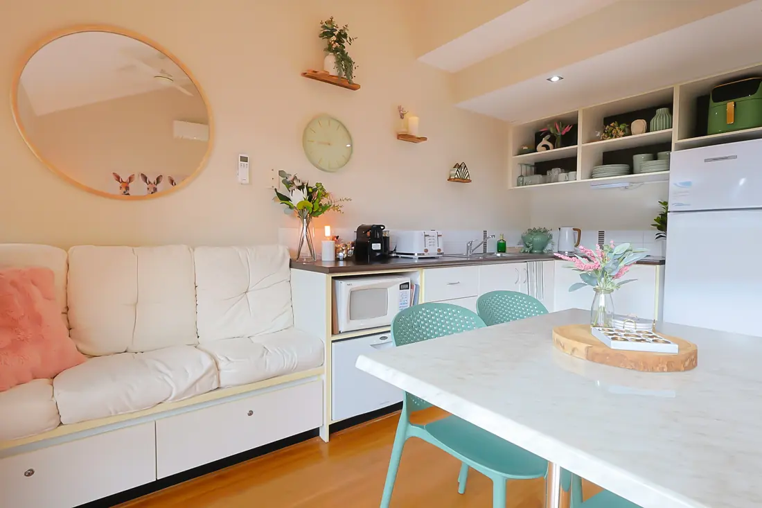 Kitchen and dining area with a white table and green chairs