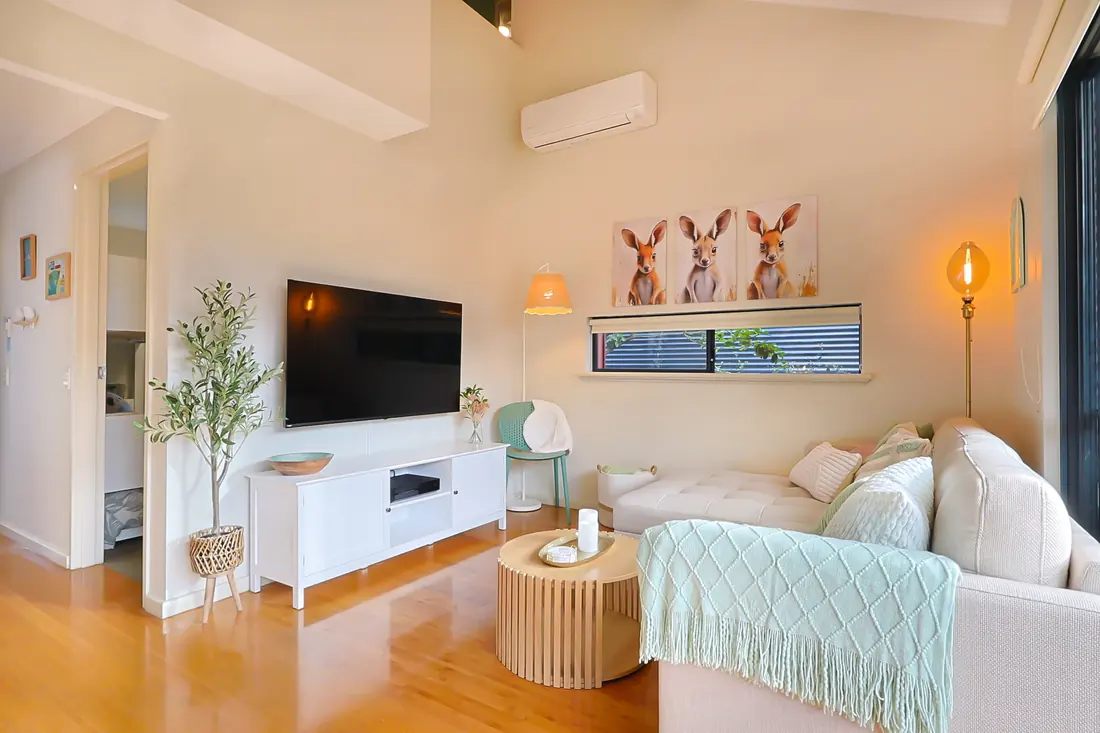Living area with a sofa, television and timber floors